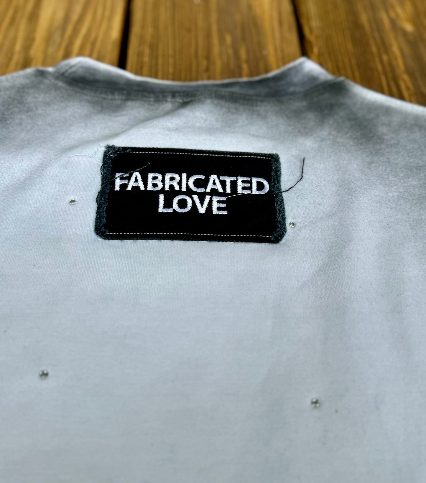 FABRICATED LOVE WHITE & BLACK “TRUST ISSUES” DROP SHOULD RHINESTONE TEE.