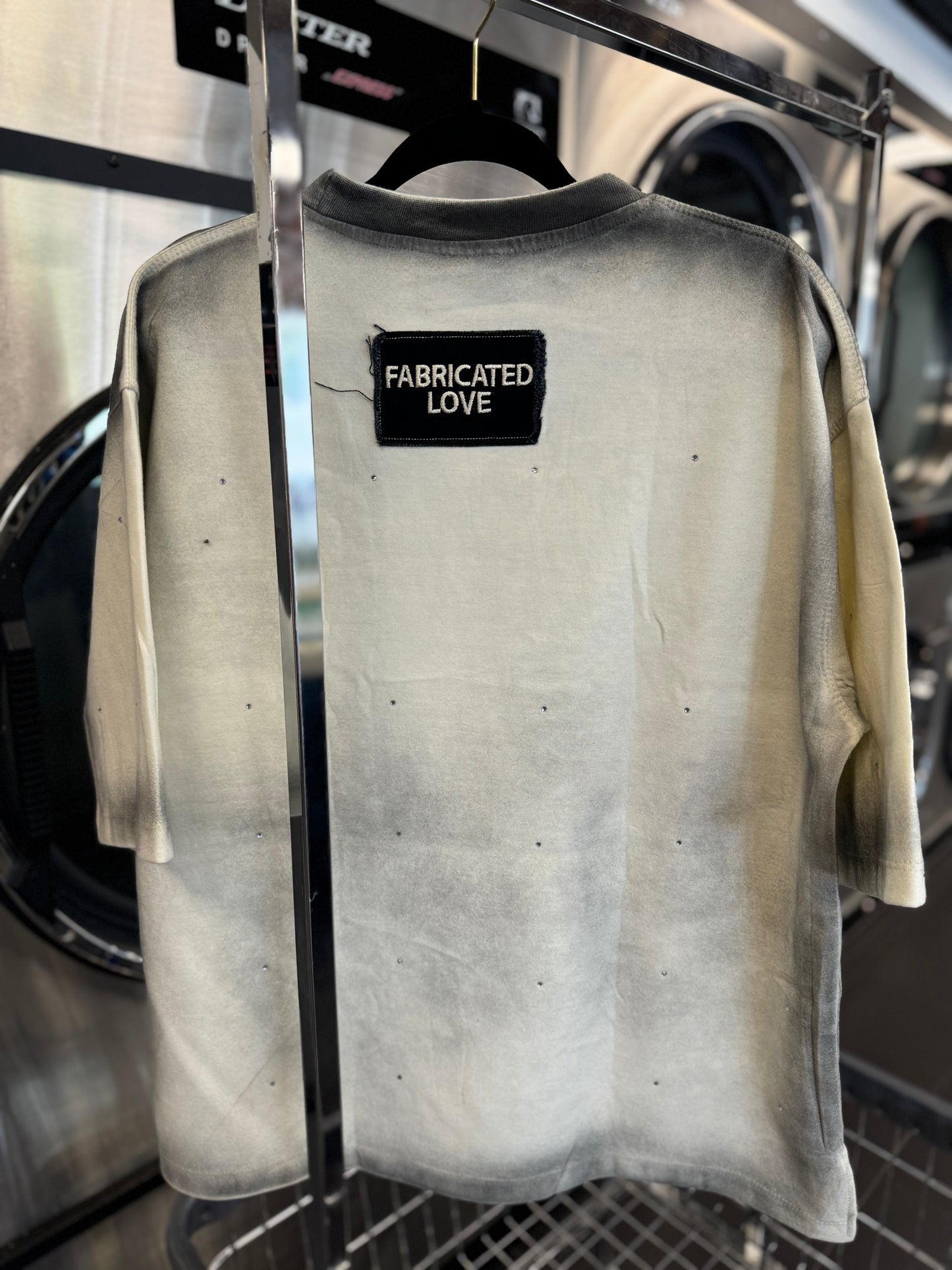 FABRICATED LOVE CREAM & BLACK “TRUST ISSUES” DROP SHOULD RHINESTONE TEE.